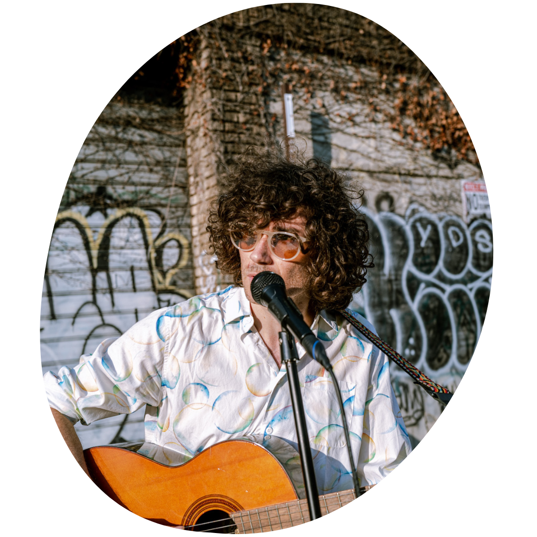 Ben plays a guitar outside in Brooklyn
